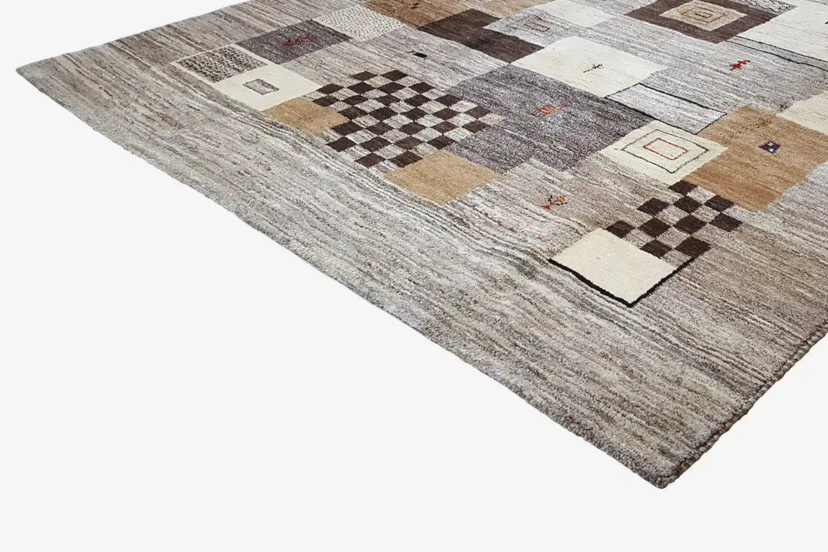 Corner view of a rug with diamond and tile patterns in gray and beige
