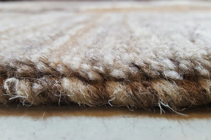 Rug edge with dense pile, brown-beige threads, and a slightly frayed edge