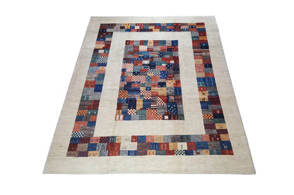 Hand-spun pure wool rug with a geometric patchwork border in blue, red, and beige