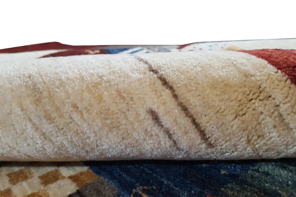 Carpet edge with beige wool pile, folded-over edge, and dark backing visible
