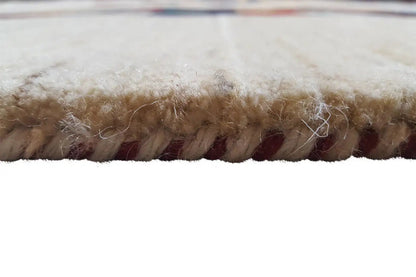 Close-up of the carpet pile at the edge, dense beige wool trim