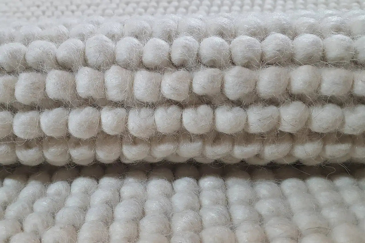 Light beige loop-textured rug, close-up of the loops