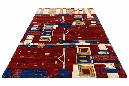 Gabbeh rug with a red background, blue border motifs, and beige-white squares