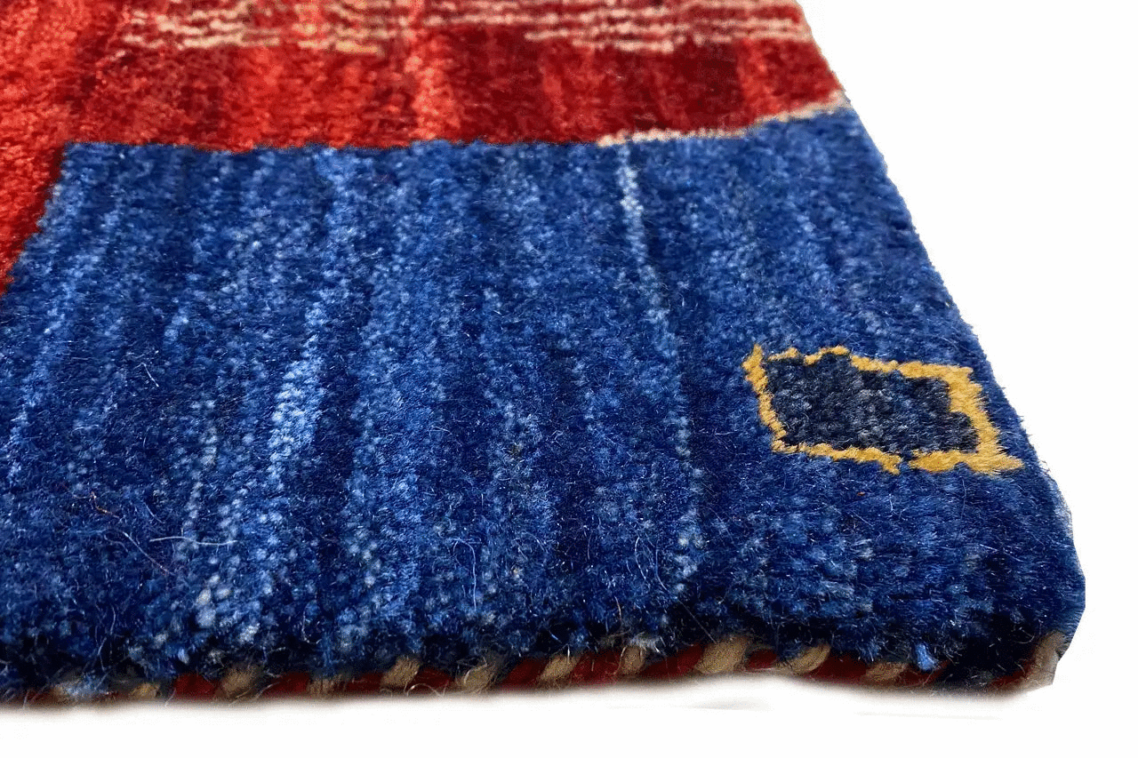Gabbeh rug detail: blue pile section with a yellow motif at the edge