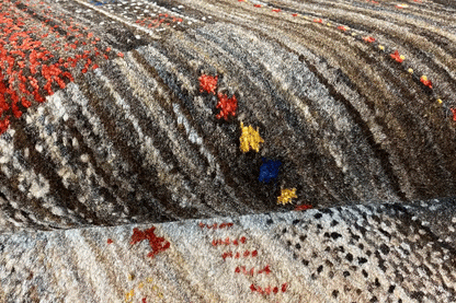 Carpet detail with a dense pile texture, gray-brown stripes and colorful dots