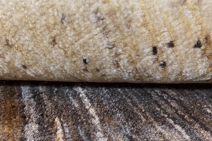 Close-up of a gabbeh rug: pile with short dark dots on a beige background
