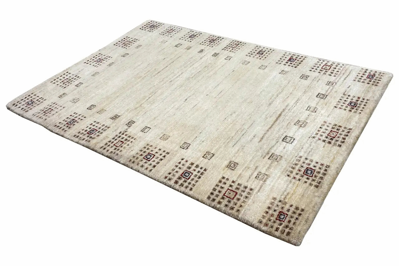 Gabbeh rug 94x64 cm shown at an angle: beige surface with small multicolored motifs