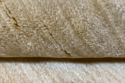Close-up of Gabbeh Lori rug: beige pile with a visible texture along the edge