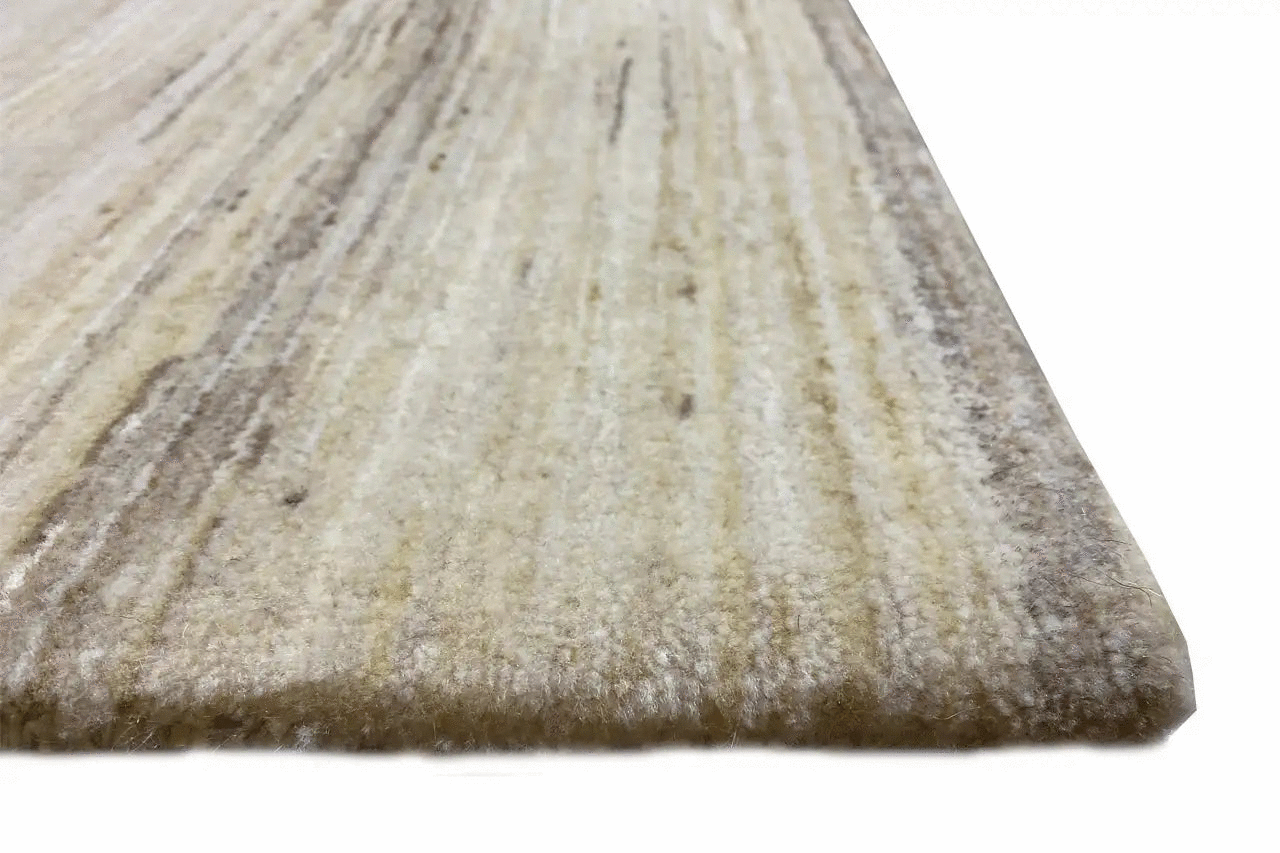 Beige wool rug with a fine pile texture, close-up at the edge