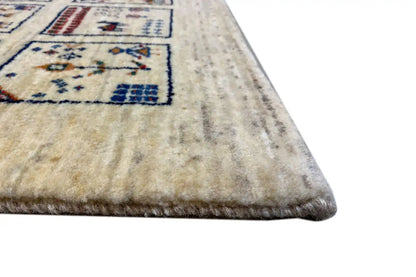 Gabbeh rug corner: beige pile with an outlined blue border pattern