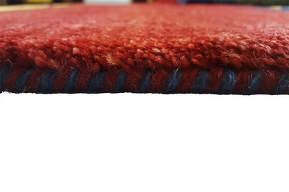 Gabbeh rug edge details: red pile with a blue fringe border