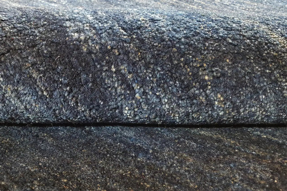 Carpet detail: dense pile in mottled blue-gray, visible edge binding