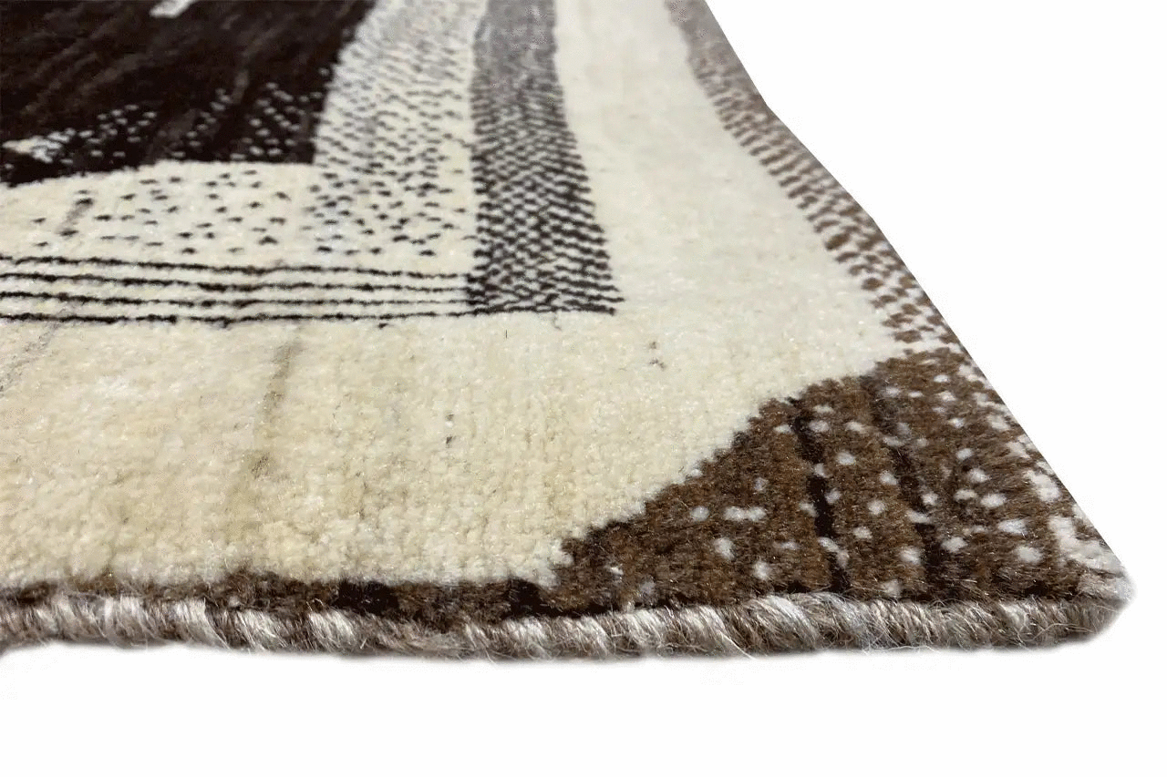 Close-up: Gabbeh rug edge with a woven border and short fringe trim.