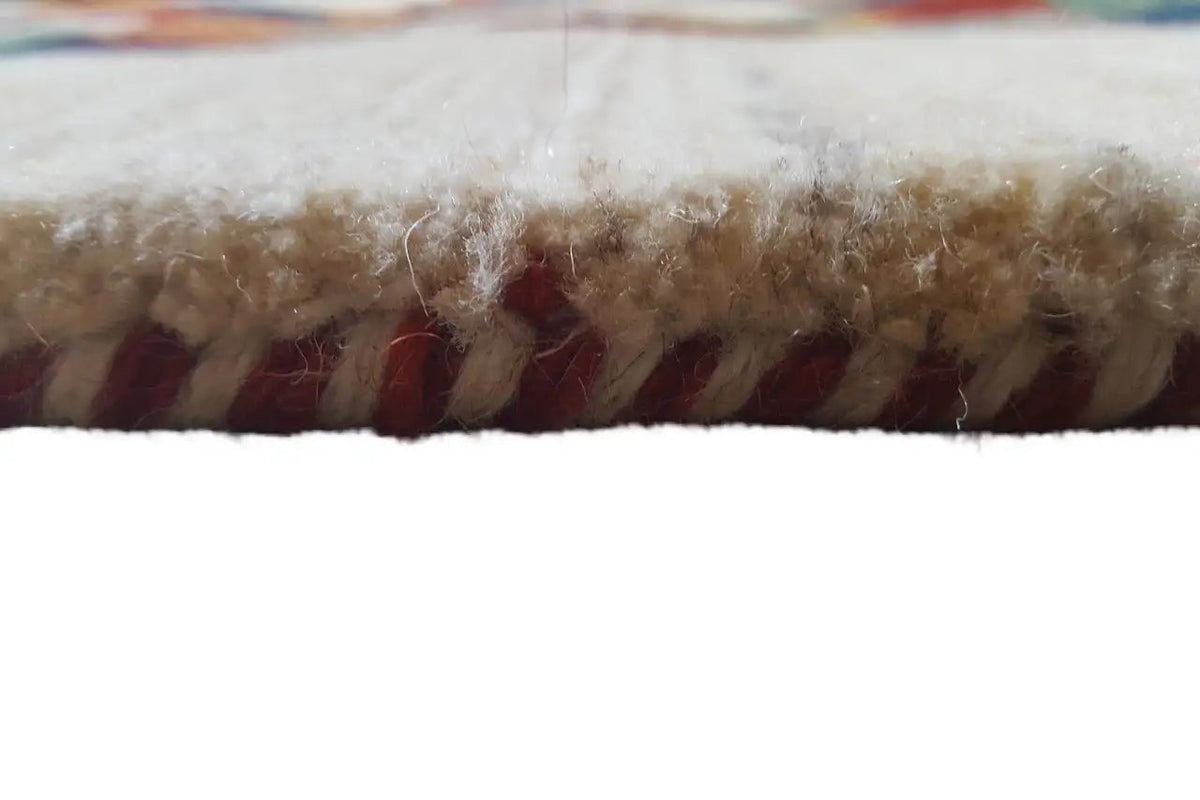 Rug edge with dense pile and short fringes, light fibers with reddish-brown accents