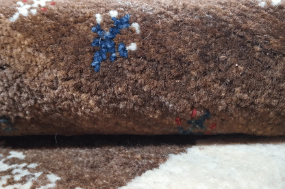 Gabbeh rug, close-up of the pile: dark brown surface with a blue ornament