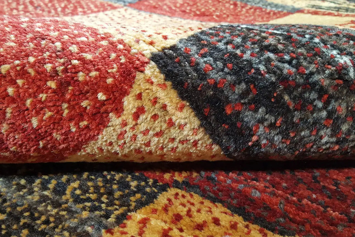 Gabbeh rug close-up: pile with red, beige, and gray areas