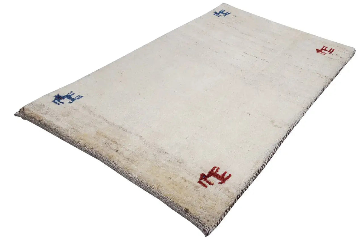 Gabbeh rug 86x56 cm, beige pile with animal motifs in red and blue, spread out at an angle