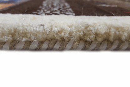Carpet edge with a beige fringe trim and brown fabric weave
