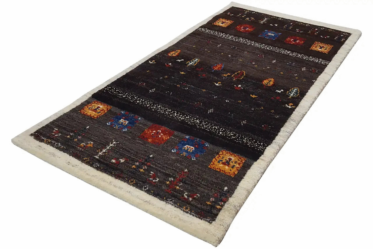 Gabbeh rug in landscape format with a dark background, colorful elements, and a light fringe border (135x66).