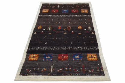 Gabbeh rug with an all-over dark stripe pattern, colorful motifs, and a beige border (135x66 cm).
