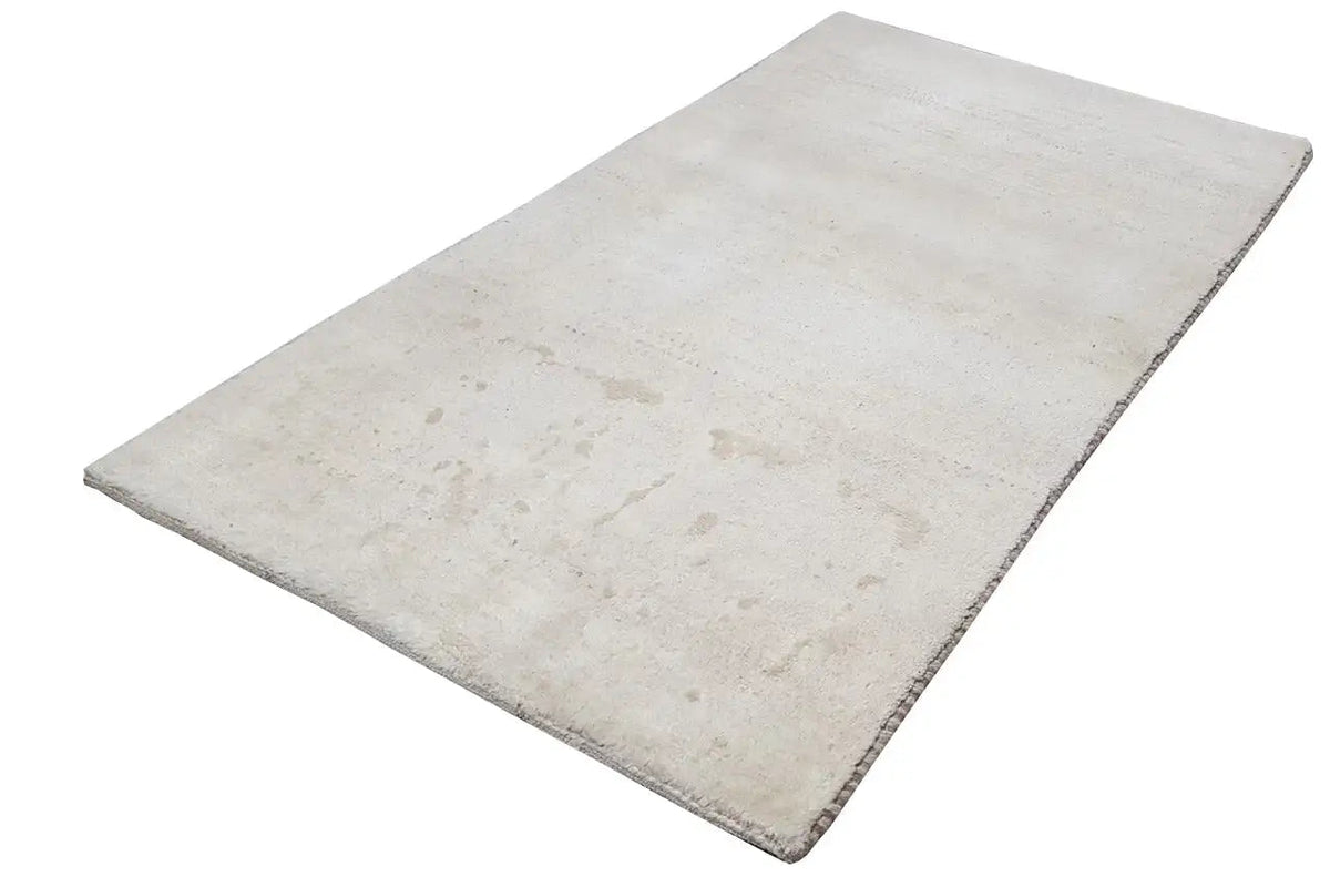 Beige rectangular rug, laid diagonally, with subtle color shading