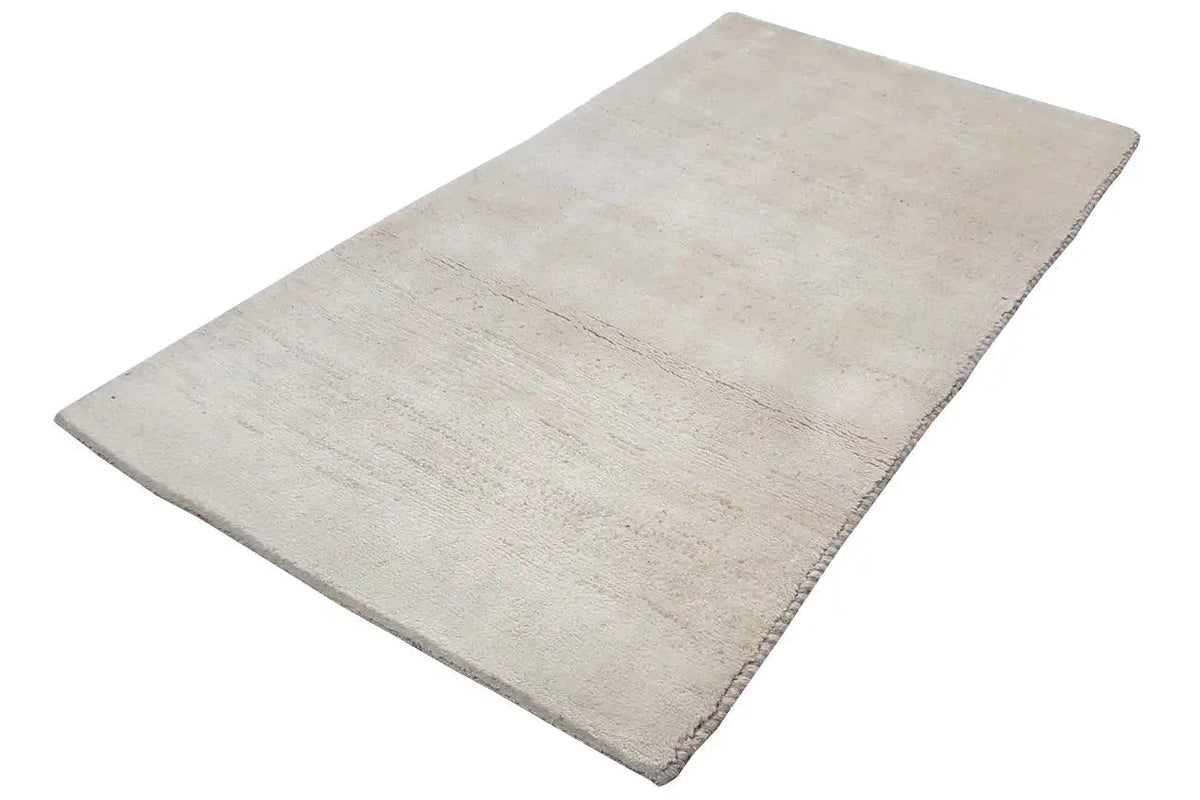 Beige rug, spread out diagonally, with an even pile texture and slight variations
