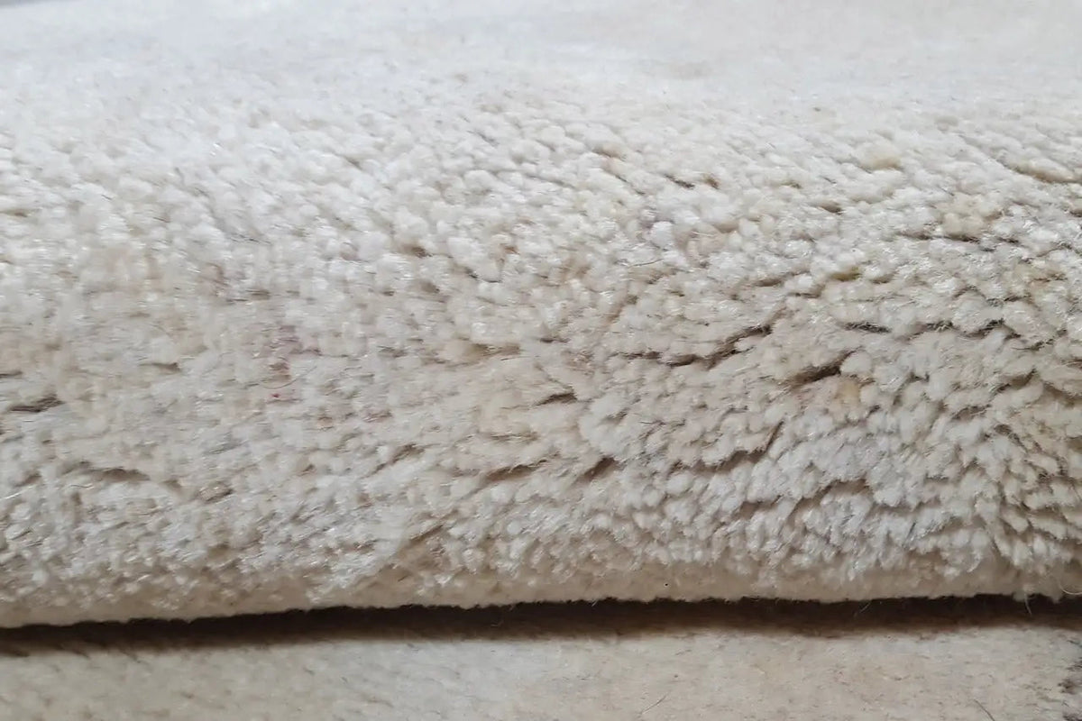 Close-up: beige pile with a dense, slightly curly texture and fine color edging