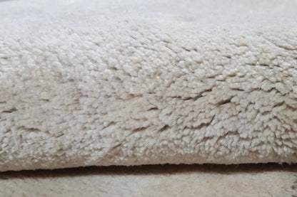 Close-up: beige pile with a dense, slightly curly texture and fine color edging