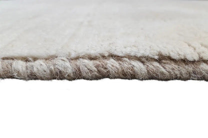 Close-up of the carpet edge with a beige pile finish and short fringes