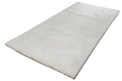 Light-colored Gabbeh rug, rectangular, wide and with a fine texture.