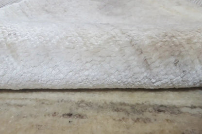 Close-up: carpet edge with loop pile and dark underside.