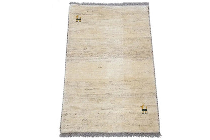 Beige Gabbeh rug, narrow dark border and fringes, animal motif