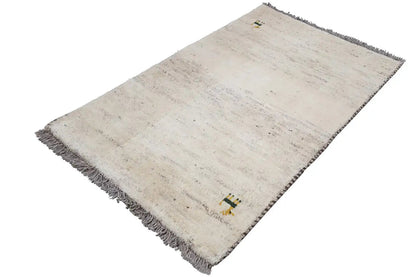 Gabbeh rug with a beige gradient, dark fringe, and a small animal motif