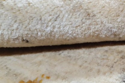 Close-up: beige carpet pile with a dense texture and dark areas
