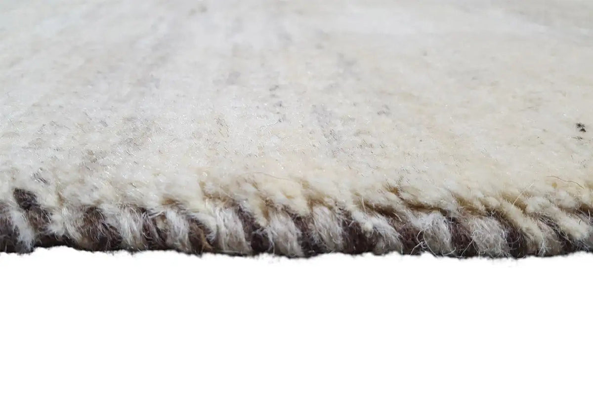 Close-up of the fringe: beige rug with dark brown edge fringe