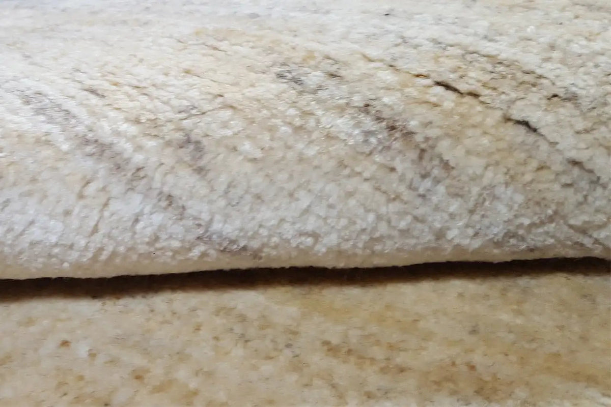 Gabbeh rug, detail view: beige pile with an irregular texture
