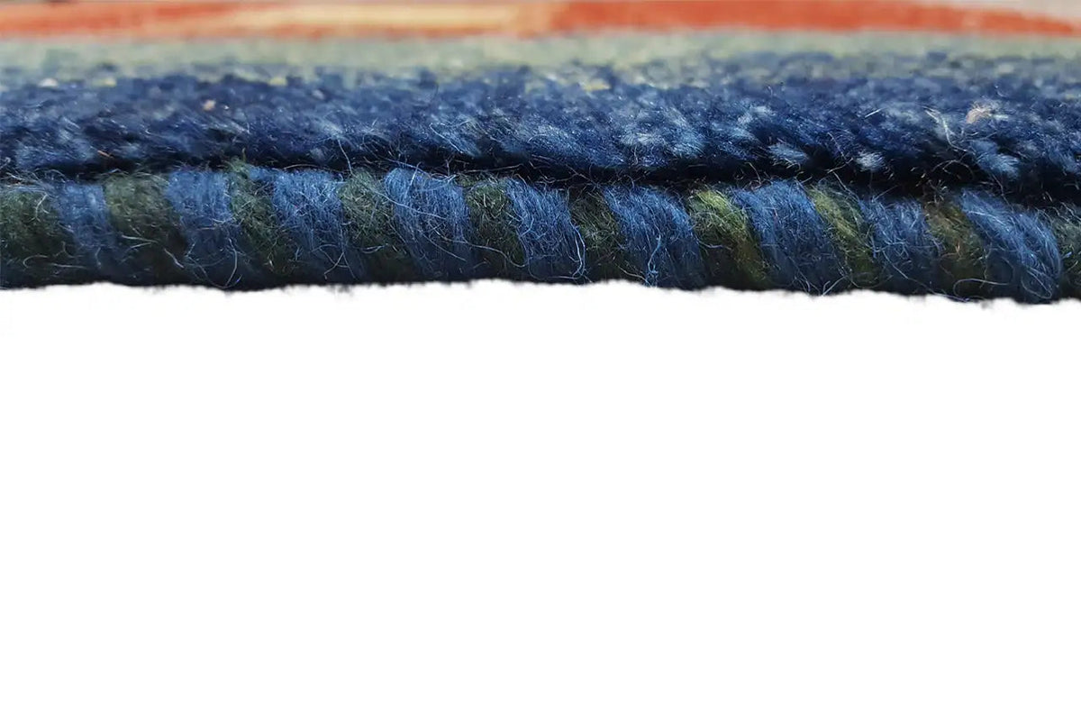 Gabbeh rug edge view with dense pile and fringes in dark blue