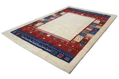 Gabbeh rug spread out, cream-colored center, red edge with blue border