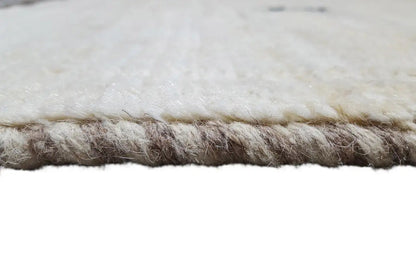 Gabbeh rug detail, cream-colored pile with dark fringe along the edge