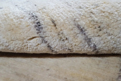 Beige rug with dark, irregular lines in the pile