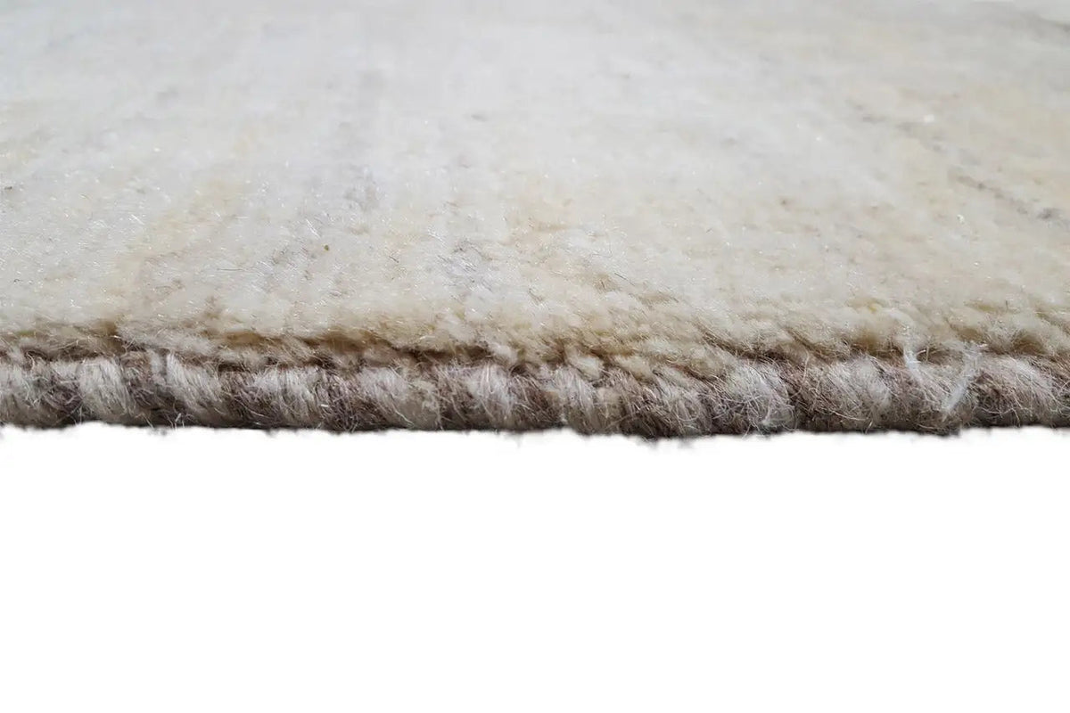 Beige rug: short loop pile at the edge with fringes