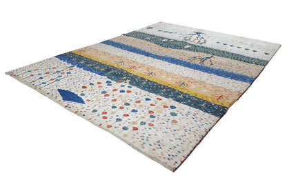 Gabbeh rug spread out with striped bands in blue and yellow, as well as small patterns