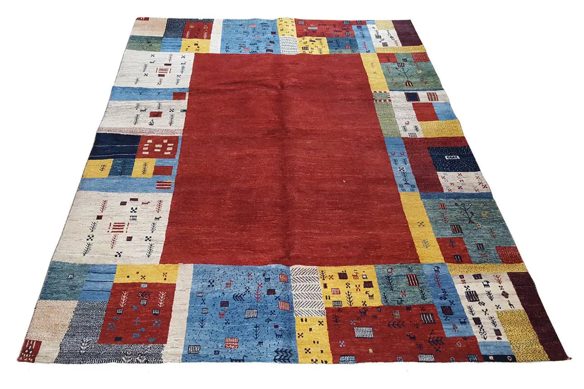 Gabbeh rug with a red center and patchwork blocks in blue, yellow, and red