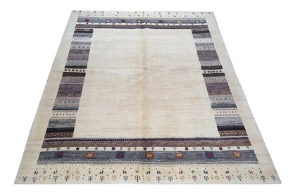 Gabbeh rug with a light center and border stripes in gray, black, and blue