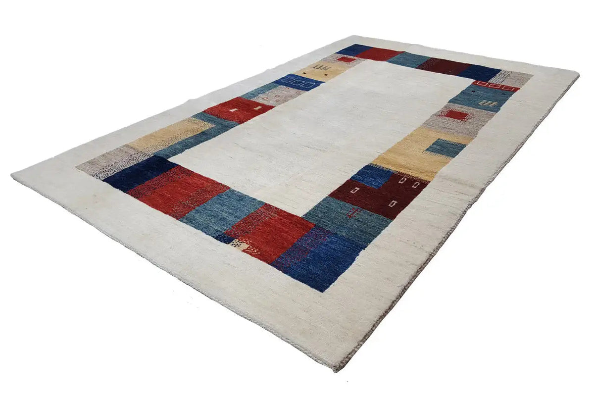 Gabbeh rug lying flat: wide patchwork band in shades of blue, red, and beige