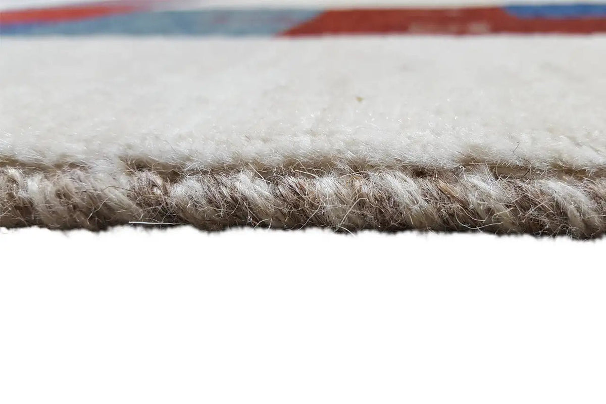 Side view of a Gabbeh rug with a dense, short pile and colorful patterns along the edge
