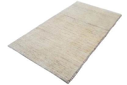 Gabbeh rug, rectangular, light beige with a subtle linear texture and fringes along the edge