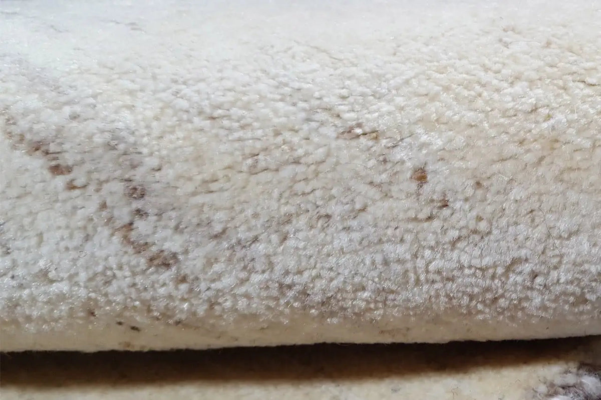 Gabbeh rug, close-up of the light beige pile with visible texture and darker spots