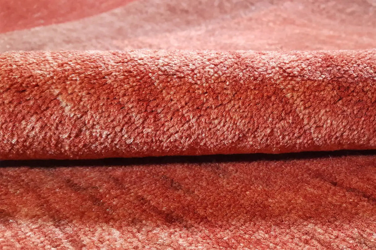 Close-up: red carpet with a dense pile and fine mottled texture