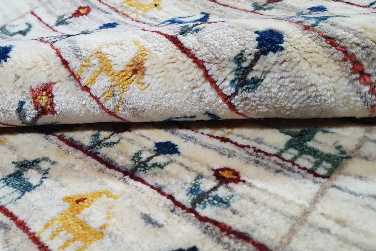 Carpet pile in detail: beige pile with multicolored embroidered motifs and red lines